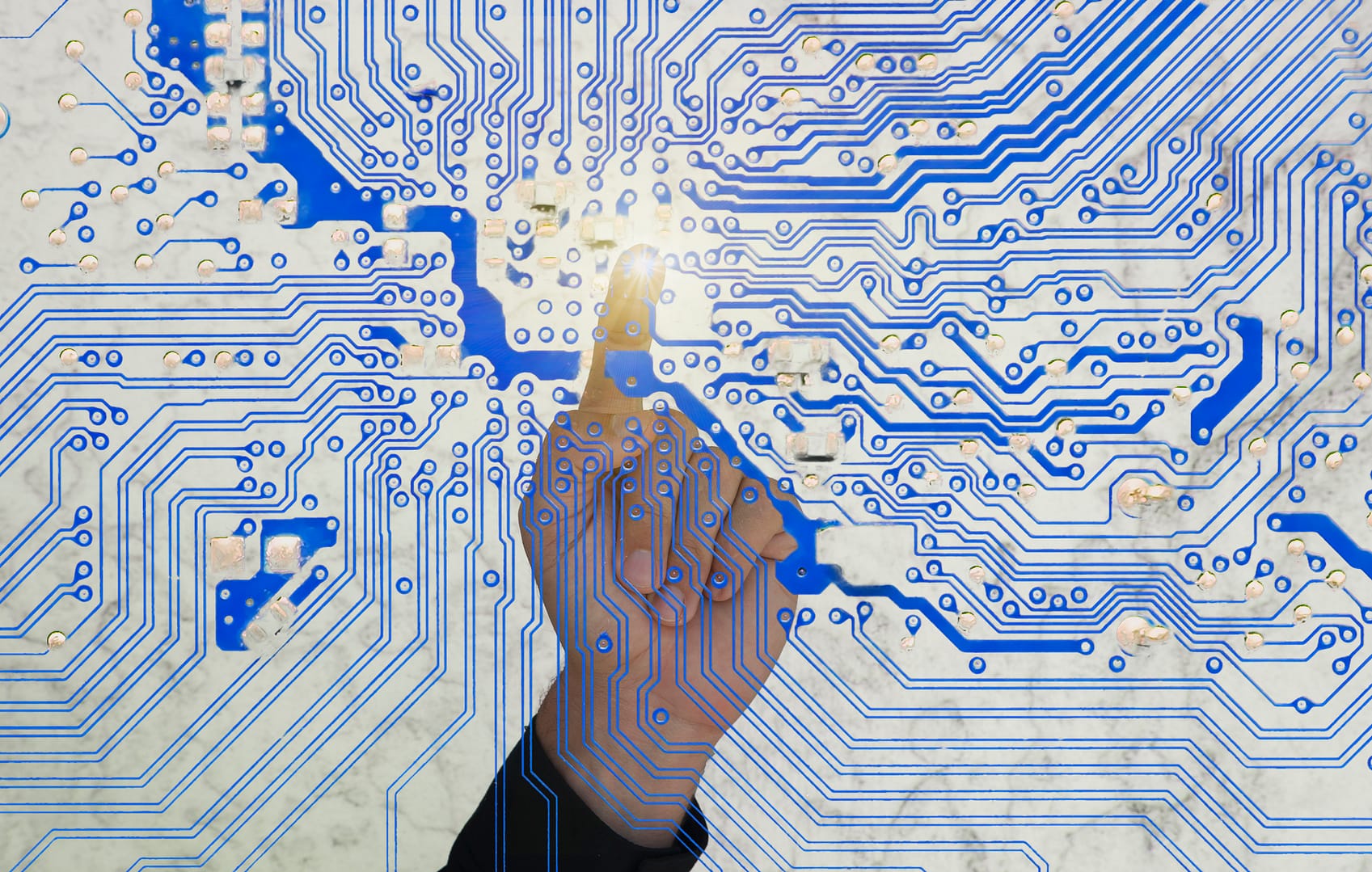man's finger pointing a circuit board